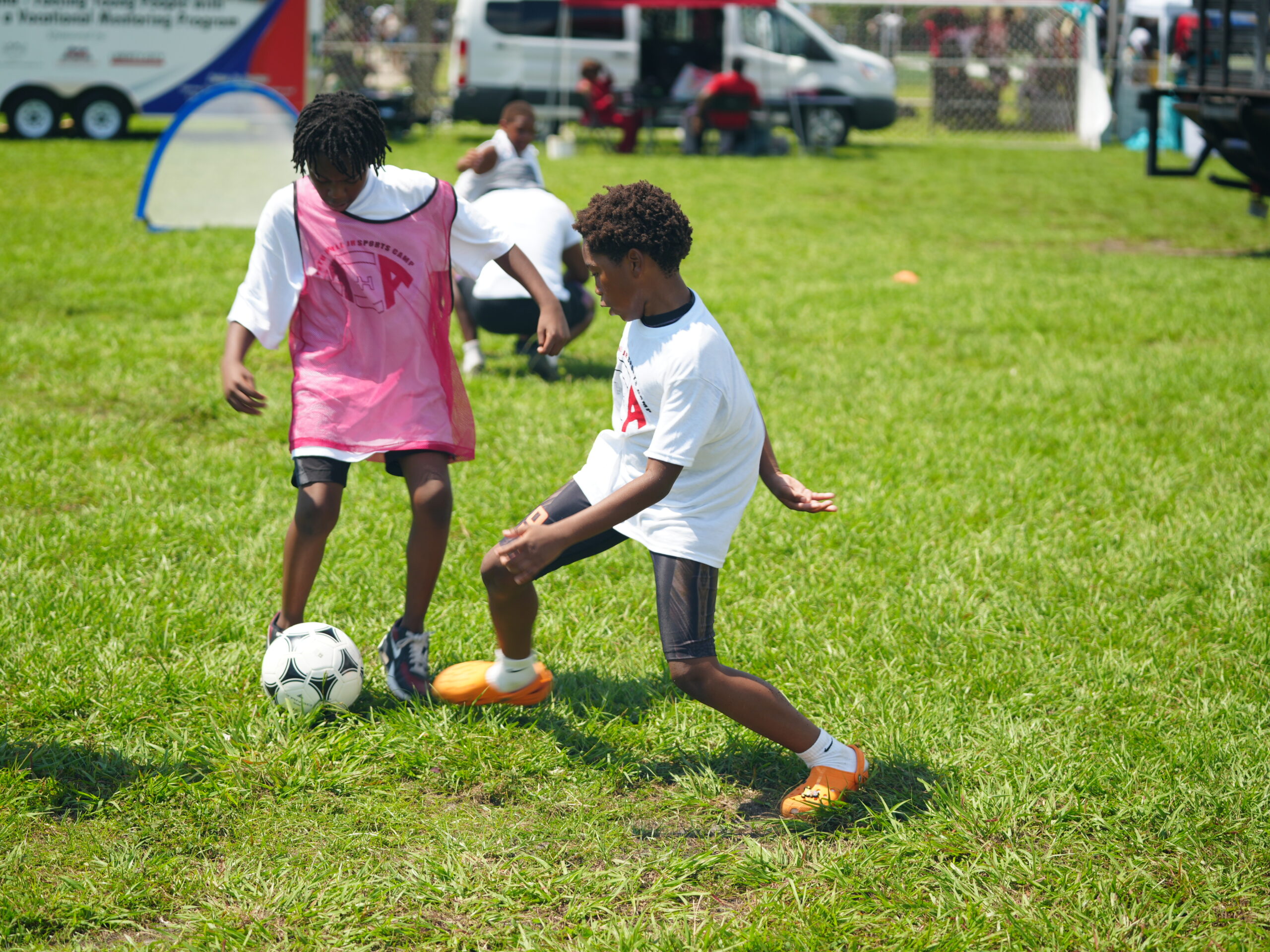 Youth playing soccer during a foundation community field day