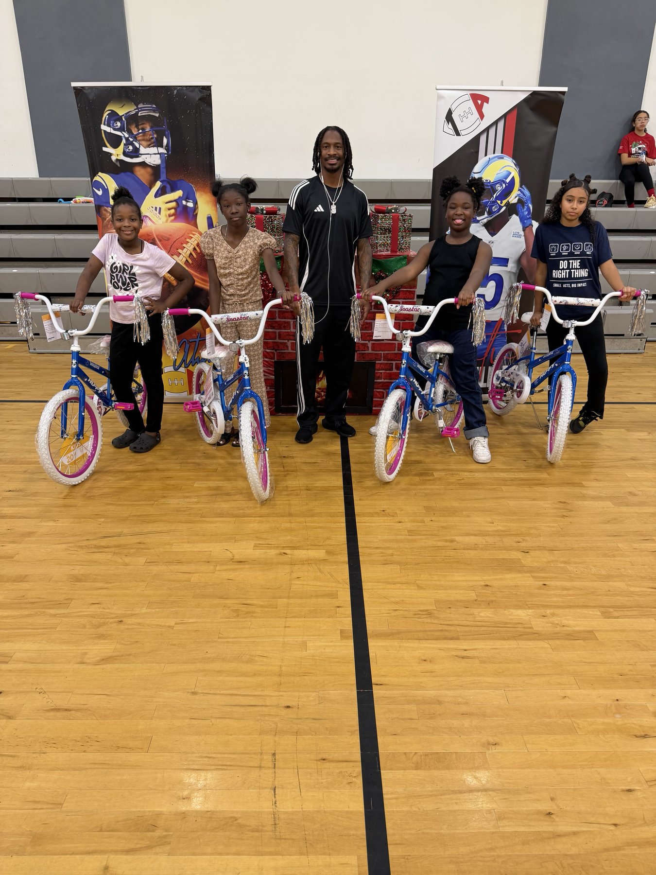 Tutu Atwell with youth participants receiving bikes at the Annual Christmas Toy Drive