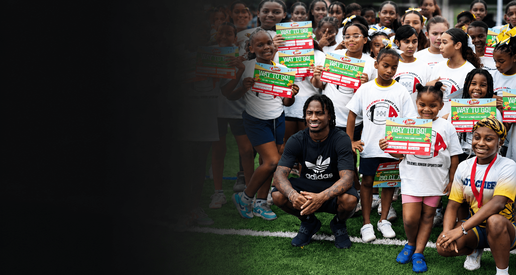 Tutu Atwell Jr. with youth participants celebrating achievement at a foundation sports camp