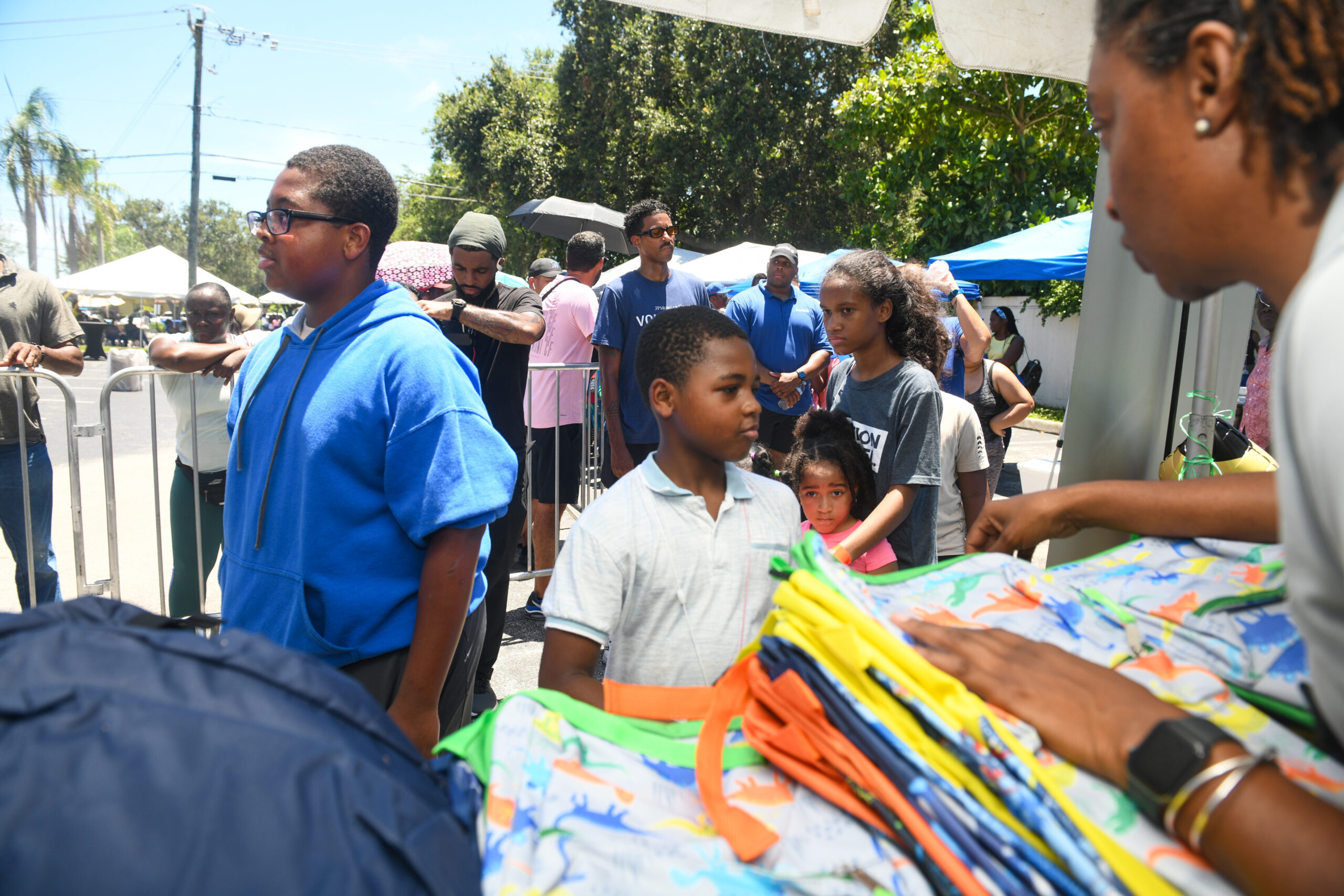 Families receiving backpacks during a back-to-school giveaway