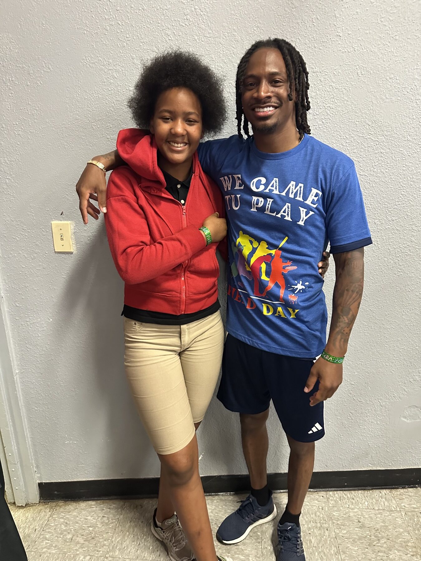 Tutu Atwell smiling with a young participant at a foundation field day