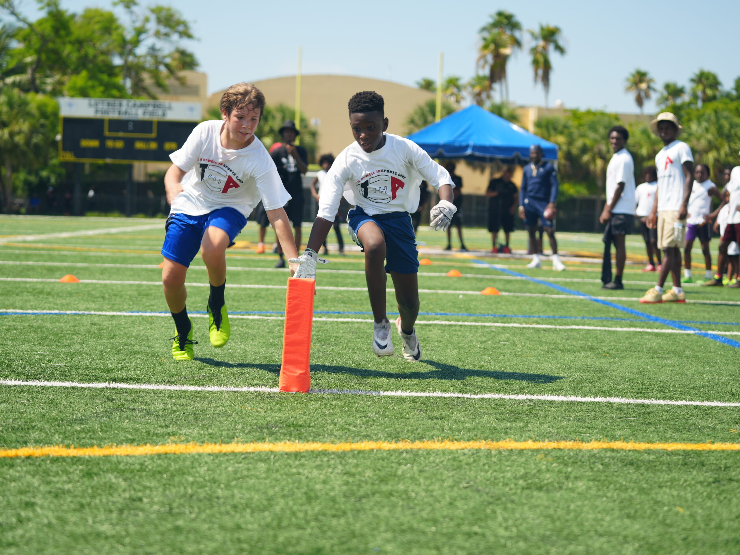 Youth athletes running sports camp drills