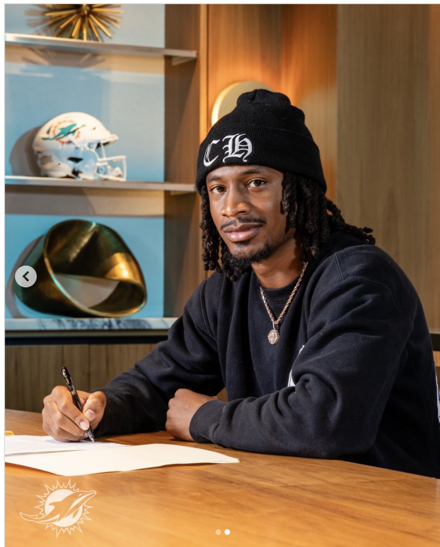 Tutu Atwell Jr. signing at a table