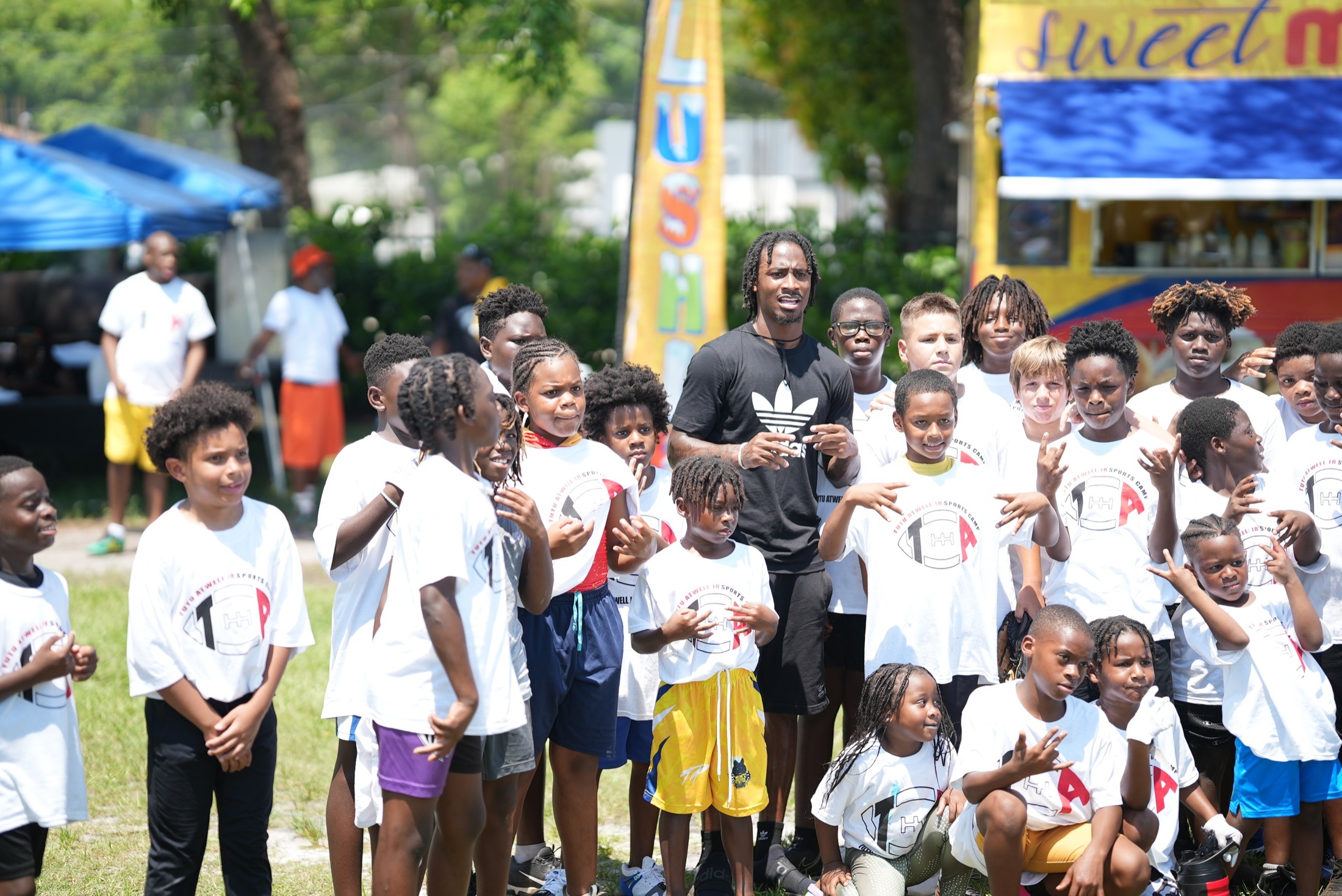Tutu Atwell standing with youth at a foundation event