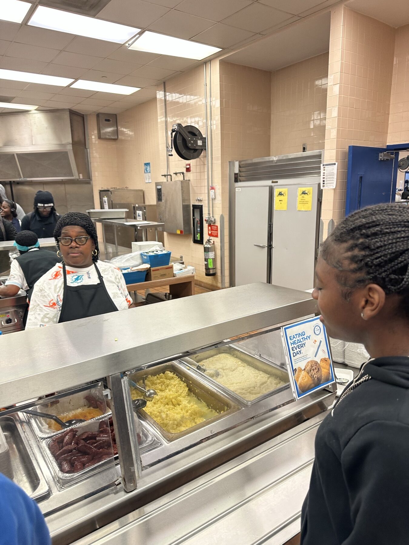 Student receiving breakfast support in a school cafeteria